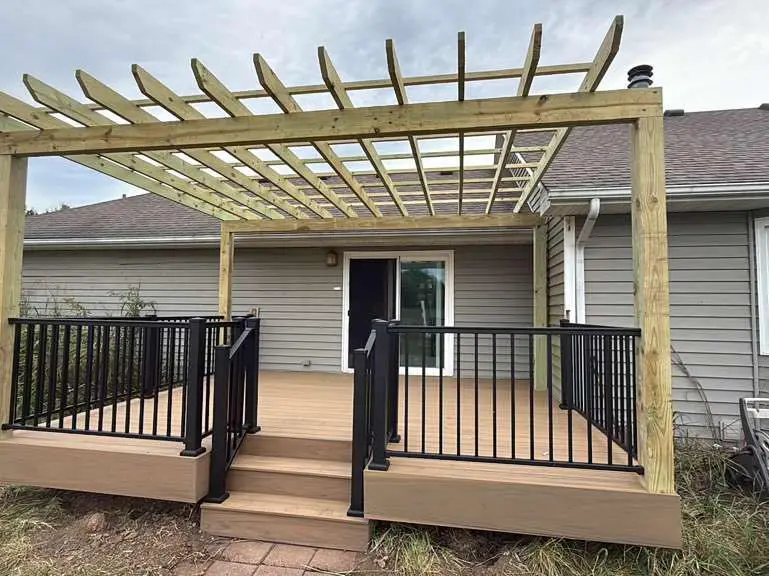 wooden pergola over a composite deck attached to a grey house in kansas city