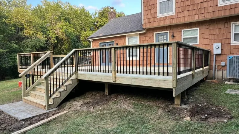 wood deck with black railing attached to a suburban home in kansas city