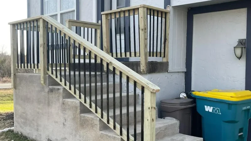 new wooden and metal railing on concrete steps leading to a home entrance in kansas city